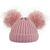 Pink knit beanie with two large fur pom-poms on a white background