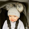 Baby boy wearing a Personalised Grey Pom Pom Hat